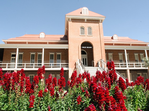 Image of Old Main on a sunny day with flowers