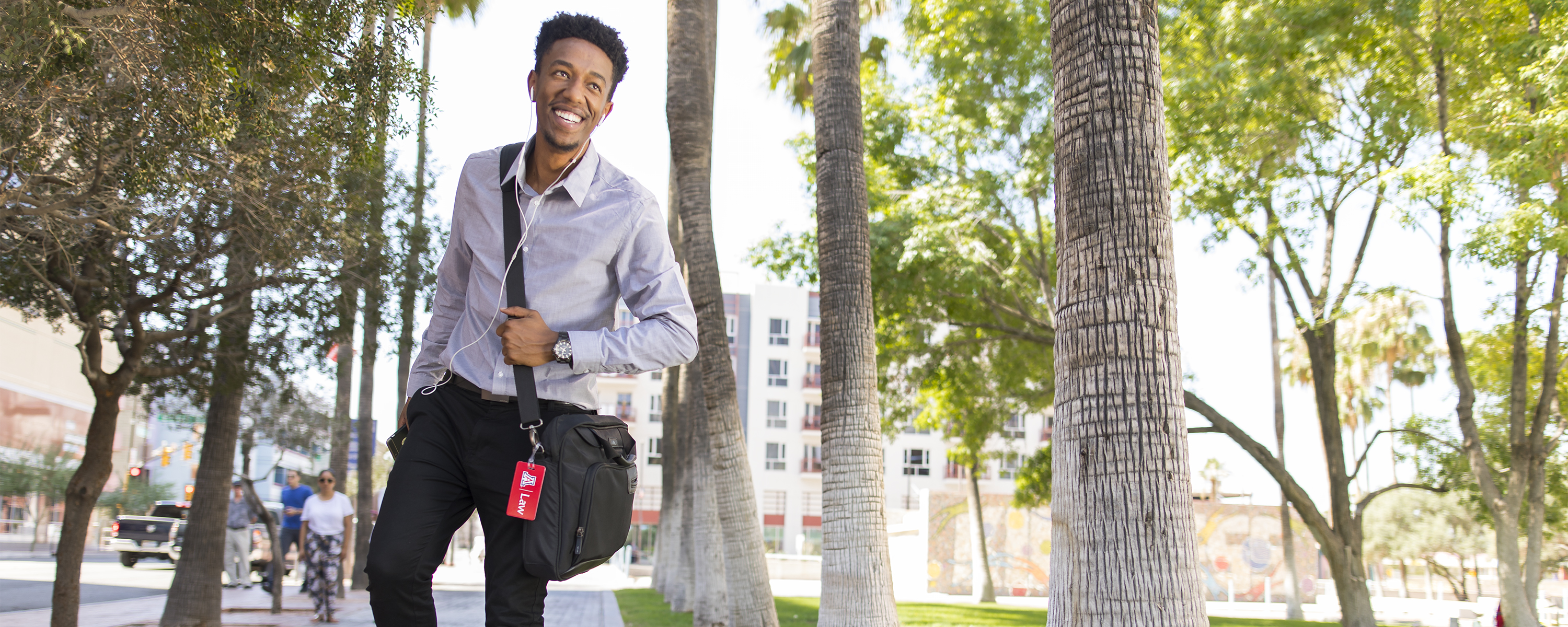 University of Arizona Law student smiling and riding a skateboard downtown