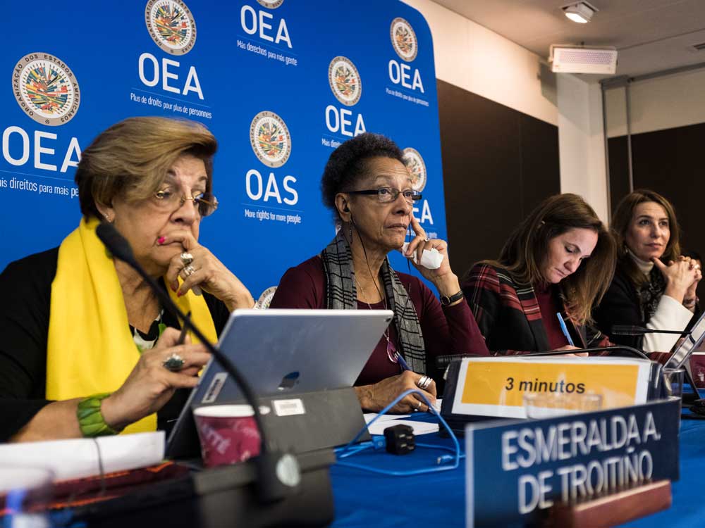 Four women listening to a speaker at an Inter-American Commission on Human Rights panel