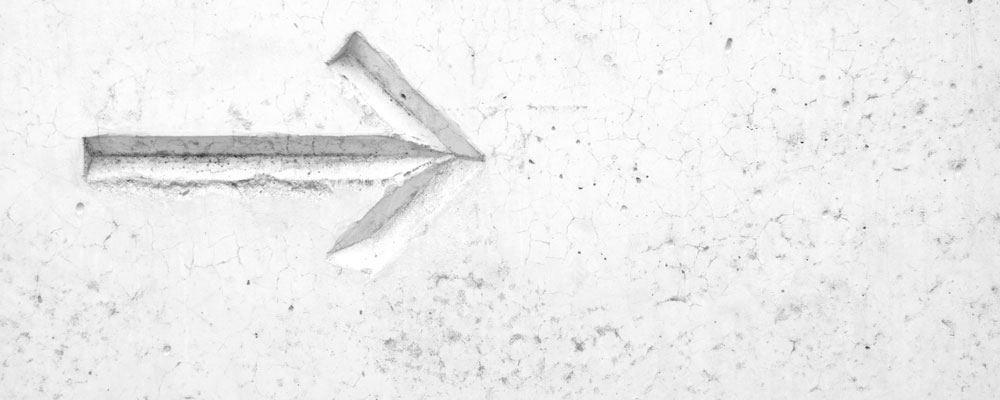 carved arrow on white wall