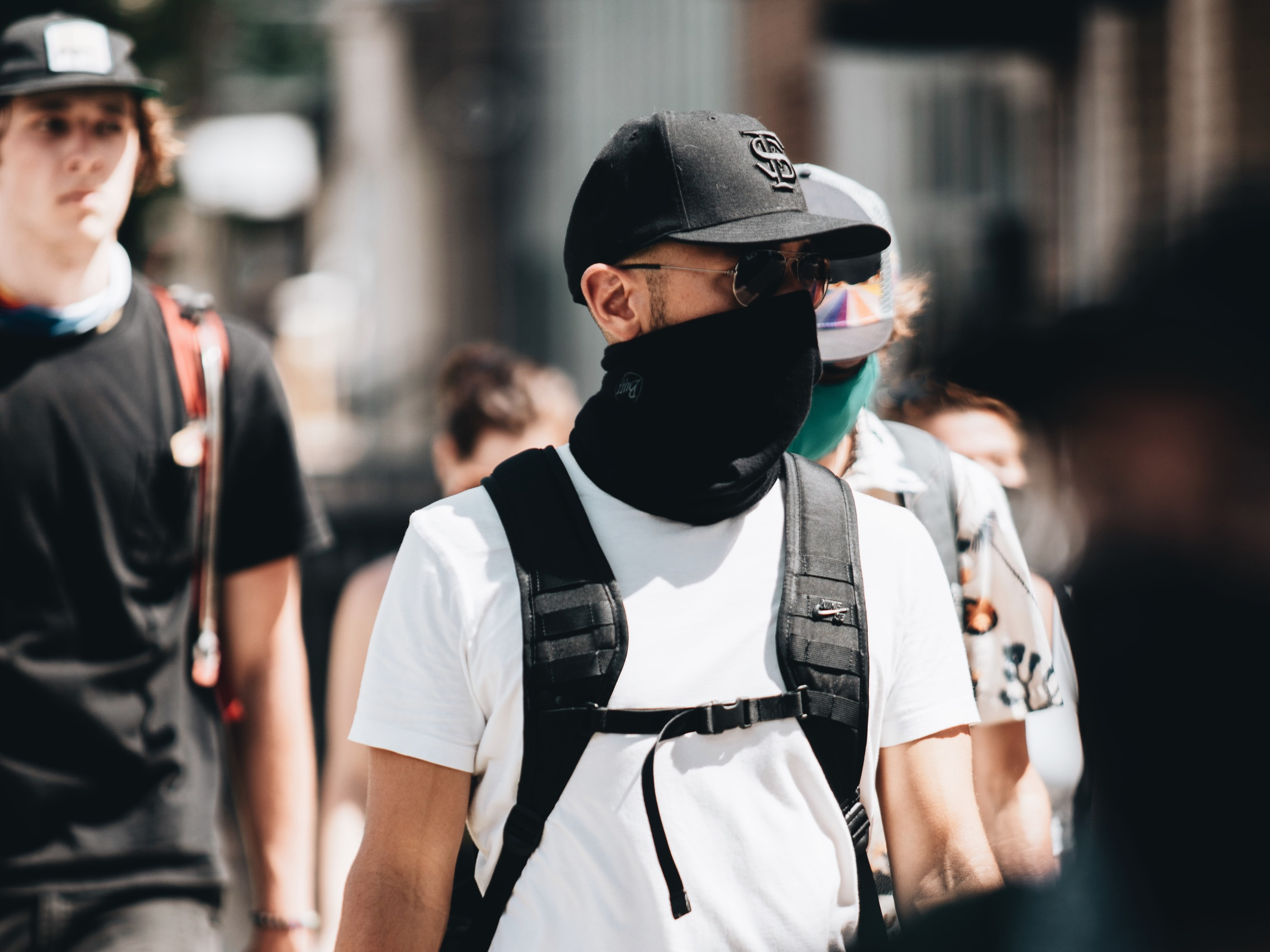 People walking on street wearing a mask 