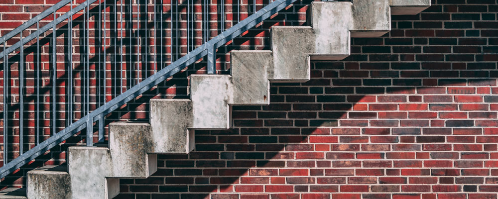 exterior stairs in front of a red brick wall