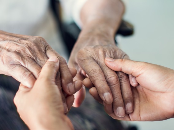 elderly hands holding younger hands for assistance