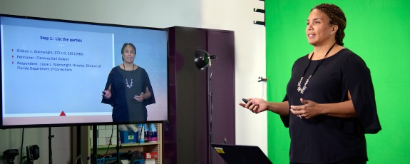 A female University of Arizona Law films a lecture in front of a green screen and monitor for an online law degree