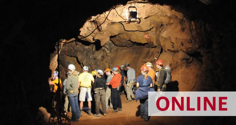 A group of people in hard hats explore a mine