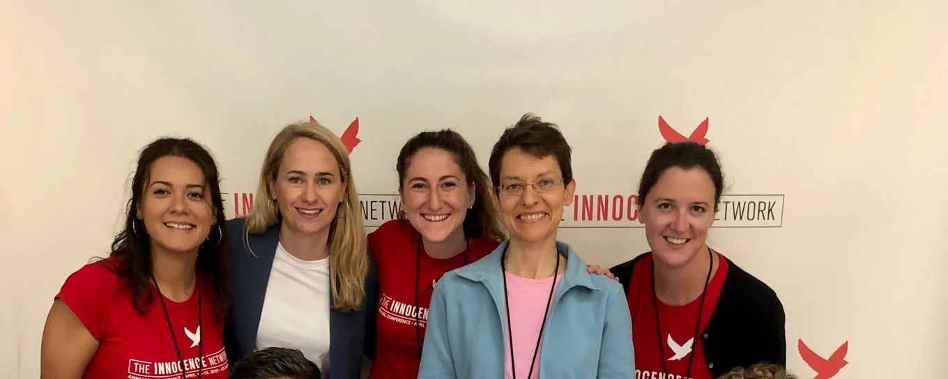 group of women in front of an Innocence Network banner