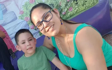 Armida and her son in front of a mural