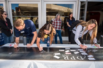 Students sign their name on the foundational steel slab during the College's Signing Ceremony.