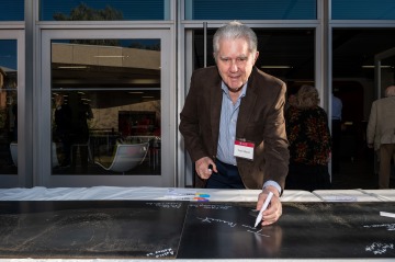 Prof. Thomas Mauet signs name during UArizona Law Signing Celebration. The college's advocacy program will be renamed the "Thomas Mauet Advocacy Program" in his honor.